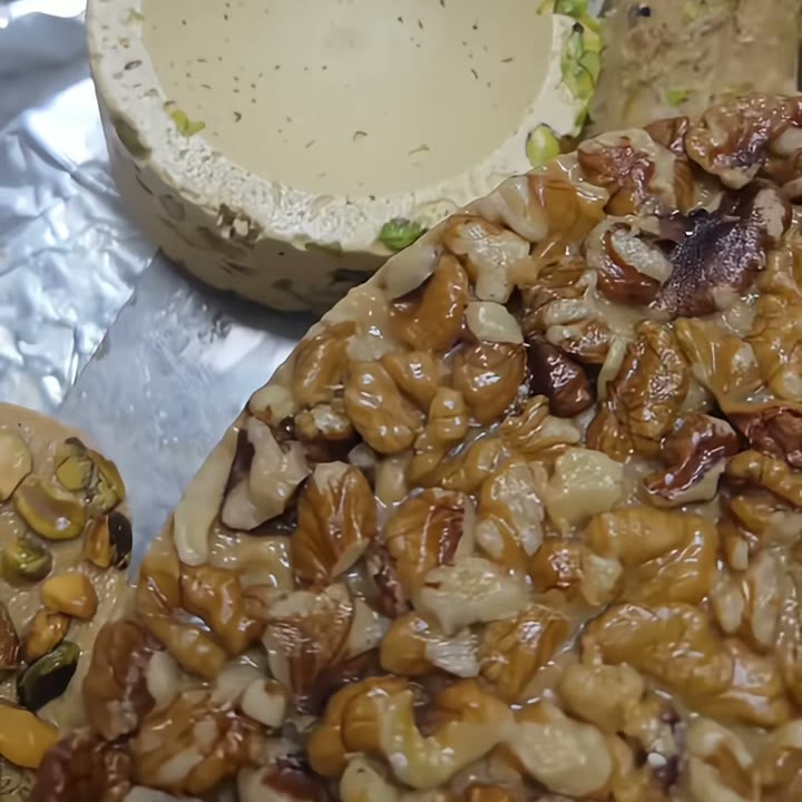 Runde Halva mit Walnusskruste, daneben eine Schale Halva